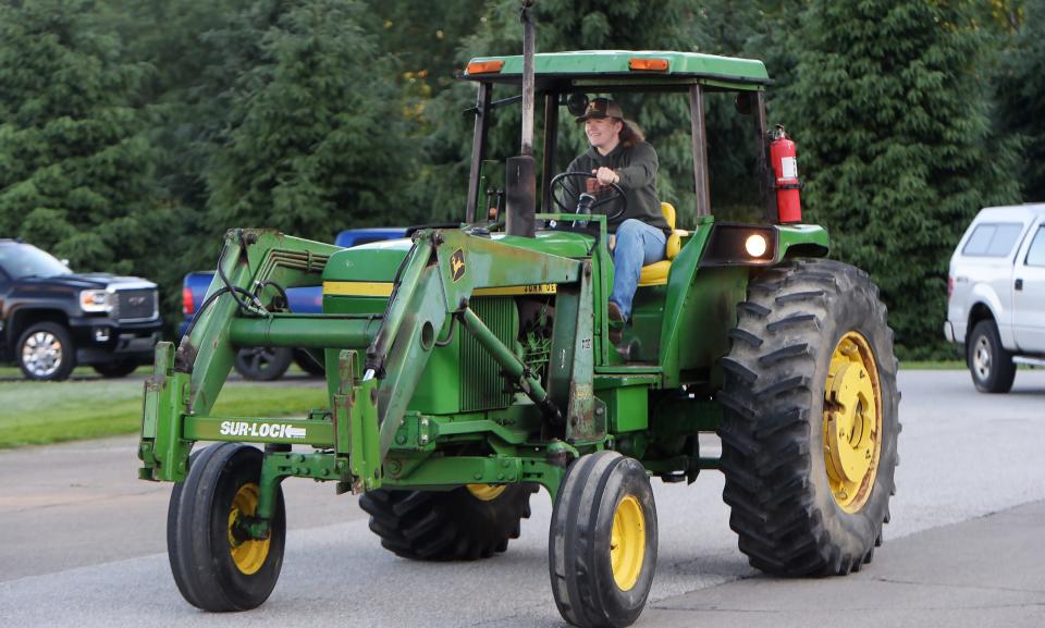 General McLane High School senior D.J. Mihalak, 18, drives his family's John Deere 4030 tractor to school on the final day of classes in Washington Township on Friday. Other students drove four-wheelers and dirt bikes to keep alive a long-running school tradition.