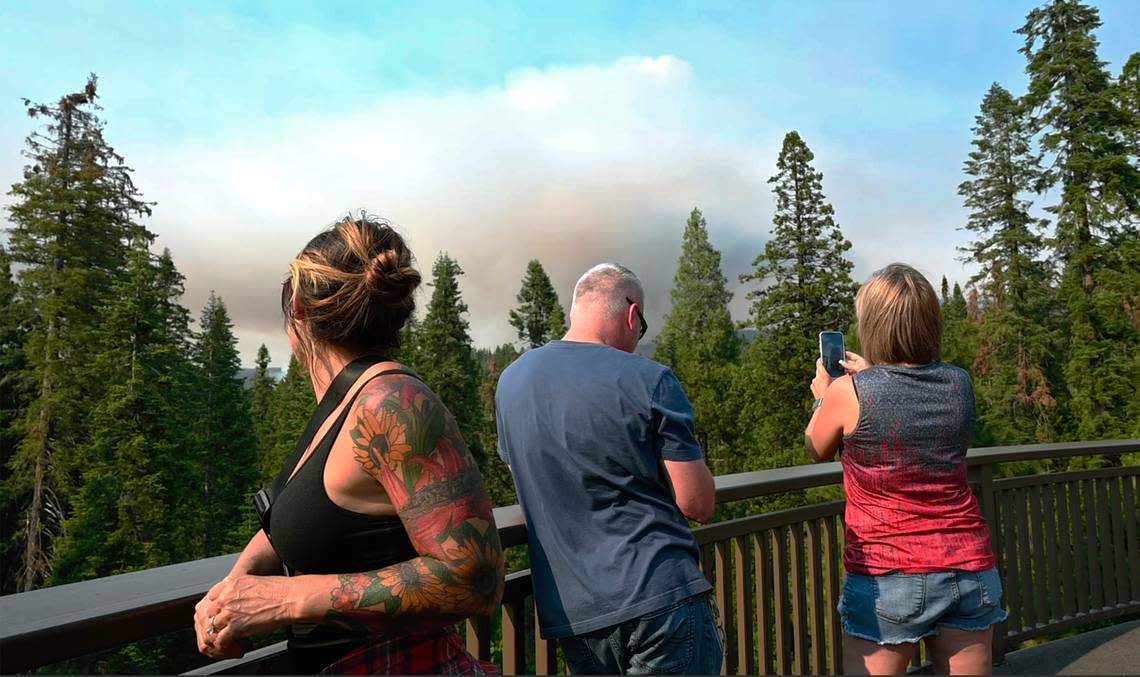 Guests at the Tenaya Lodge watch the Washburn Fire from a balcony as it burns near the south entrance of Yosemite National Park Saturday, July 9, 2022 in Fish Camp.