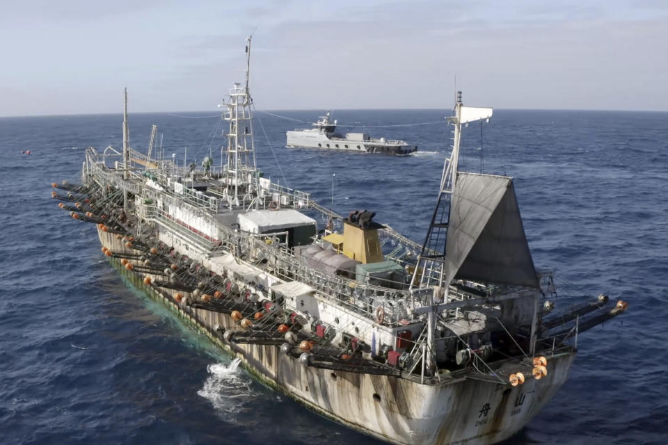 In this July 2021 photo provided by Sea Shepherd, the Ocean Warrior, background, circles a Chinese-flagged vessel on the high seas off the west coast of South America. (Isaac Haslam/Sea Shepherd via AP)