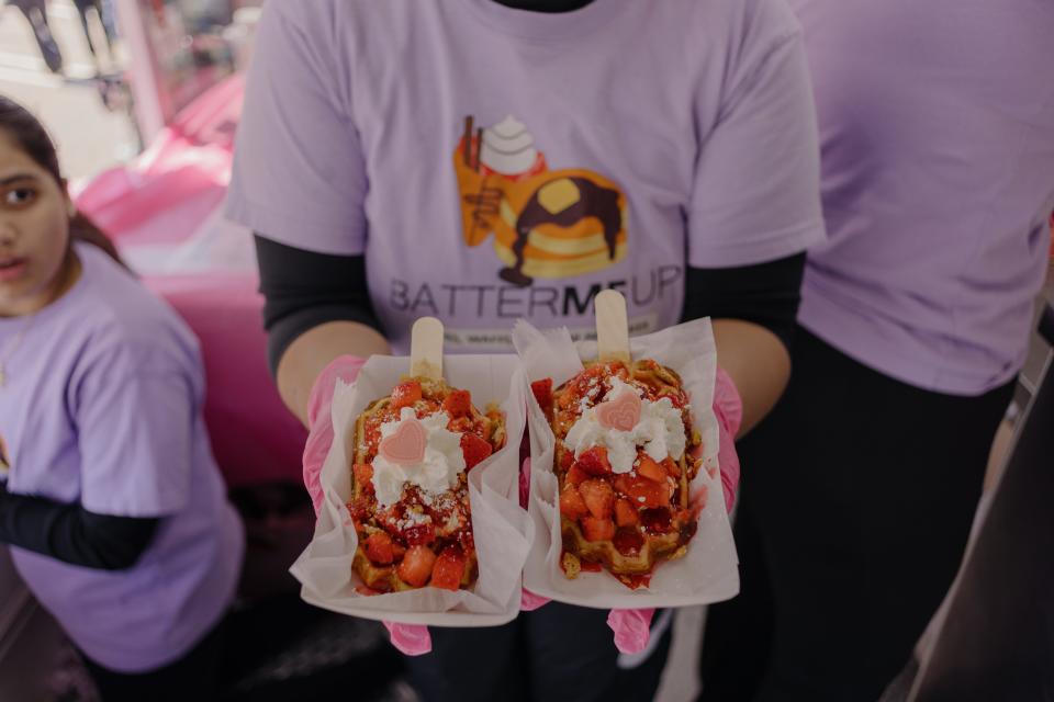Kathy Quiroga holds two strawberry cheesecake waffle treats