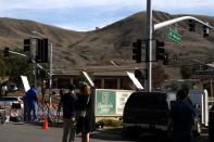 Media report as personnel collect debris while working with investigators at the helicopter crash site of NBA star Kobe Bryant in Calabasas, California