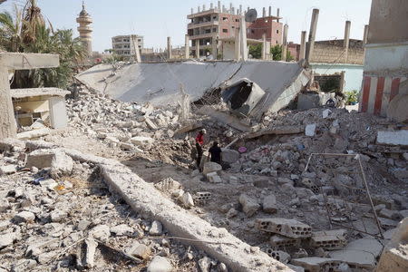 Residents inspect damage from what activists said were barrel bombs dropped by forces loyal to Syria's President Bashar Al-Assad in Tafas town in Daraa, Syria, July 2, 2015. REUTERS/Alaa Al-Faqir