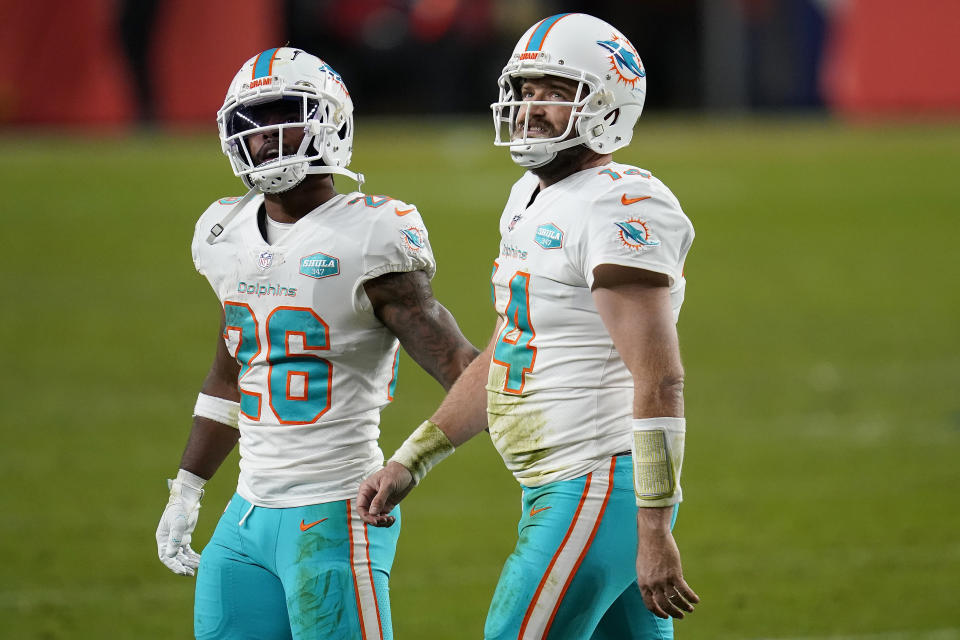 Miami Dolphins quarterback Ryan Fitzpatrick (14) walks off the field with running back Salvon Ahmed (26) during the second half of an NFL football game abasing the Denver Broncos, Sunday, Nov. 22, 2020, in Denver. The Bronco won 20-13. (AP Photo/David Zalubowski)