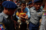 Detained Reuters journalist Kyaw Soe Oo holds his daughter as he is escorted by police while arriving for a court hearing after a lunch break in Yangon, Myanmar February 21, 2018. REUTERS/Stringer