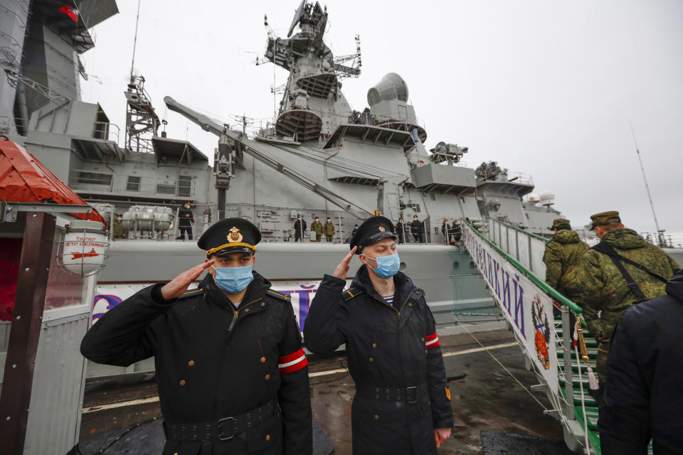 Russian sailors salute as they stand guard at the Northern Fleet's flagship, the Pyotr Veilikiy (Peter the Great) missile cruiser, at its Arctic base of Severomorsk, Russia, Thursday, May 13, 2021. Adm. Alexander Moiseyev, the commander of Russia's Northern Fleet griped Thursday about increased NATO's military activities near the country's borders, describing them as a threat to regional security. (AP Photo/Alexander Zemlianichenko)