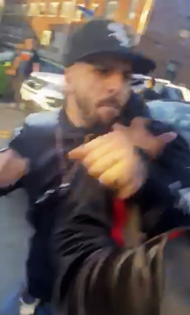 In this April 29, 2020, image made from video provided by Adegoke Atunbi, an unmasked New York City police officer in plain clothes begins to wrestle a man to the ground while making an arrest in the Brooklyn borough of New York. The video is among those posted on social media recently that show the NYPD using physical force while out enforcing the city's 6-foot-of-distance social distance rule. Despite mounting pressure from watchdogs to stop using police to enforce social distancing, Mayor Bill de Blasio stood by the practice on Thursday, May 7, saying: "We're not going to sideline the NYPD." (Adegoke Atunbi via AP)