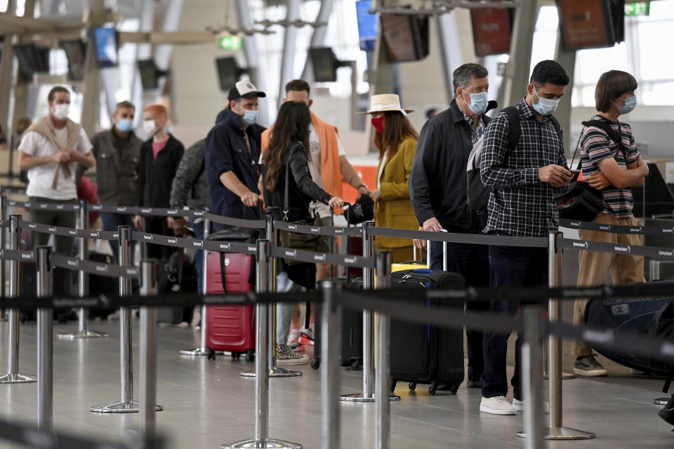 Passengers wear face masks as they check in at the Jetstar terminal at Sydney Domestic Airport in Sydney, Australia Friday, Nov. 5, 2021. Flights between New South Wales and Victoria have resumed without any COVID-19 restrictions, as the border between the two states reopens. (Bianca De Marchi/AAP Image via AP)
