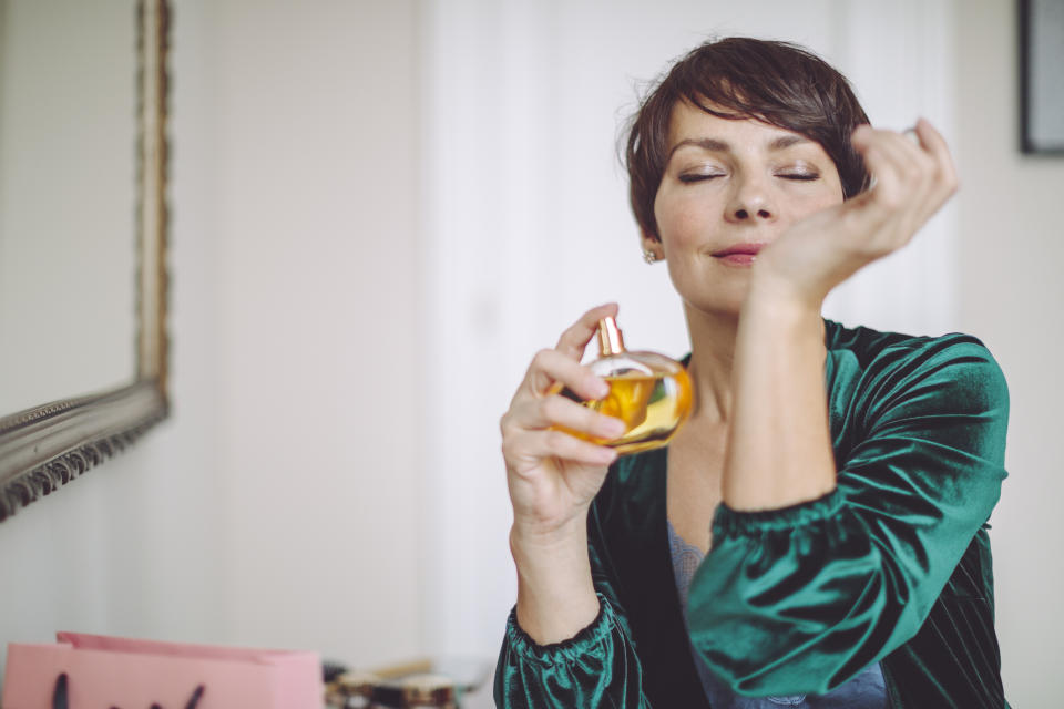 mature woman smelling pheromone perfume on wrist