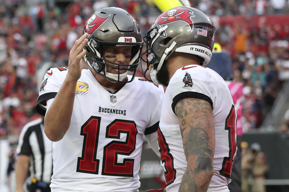 Tampa Bay Buccaneers quarterback Tom Brady (12) celebrates with wide receiver Mike Evans (13) after Evans couaght a touchdown pass during the first half of an NFL football game against the Chicago Bears Sunday, Oct. 24, 2021, in Tampa, Fla. (AP Photo/Mark LoMoglio)