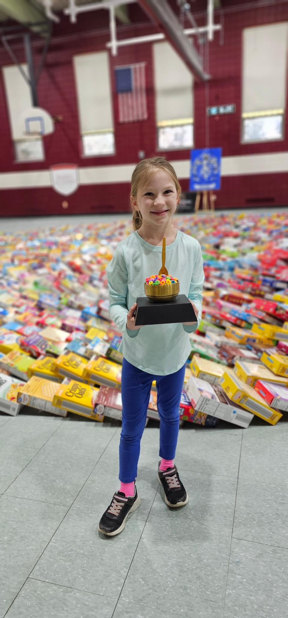Second-grader Amelia Sorge poses with the "golden cereal bowl," the ultimate prize of Baden Academy's Cereal Bowl competition.