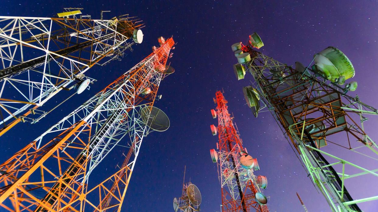 Telecommunication mast with microwave link and TV transmitter antennas in night sky .