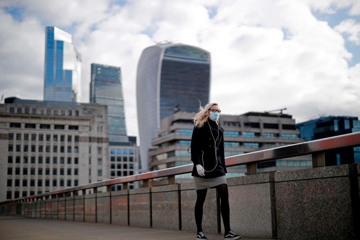 A woman wearing PPE walks in London: AFP via Getty Images