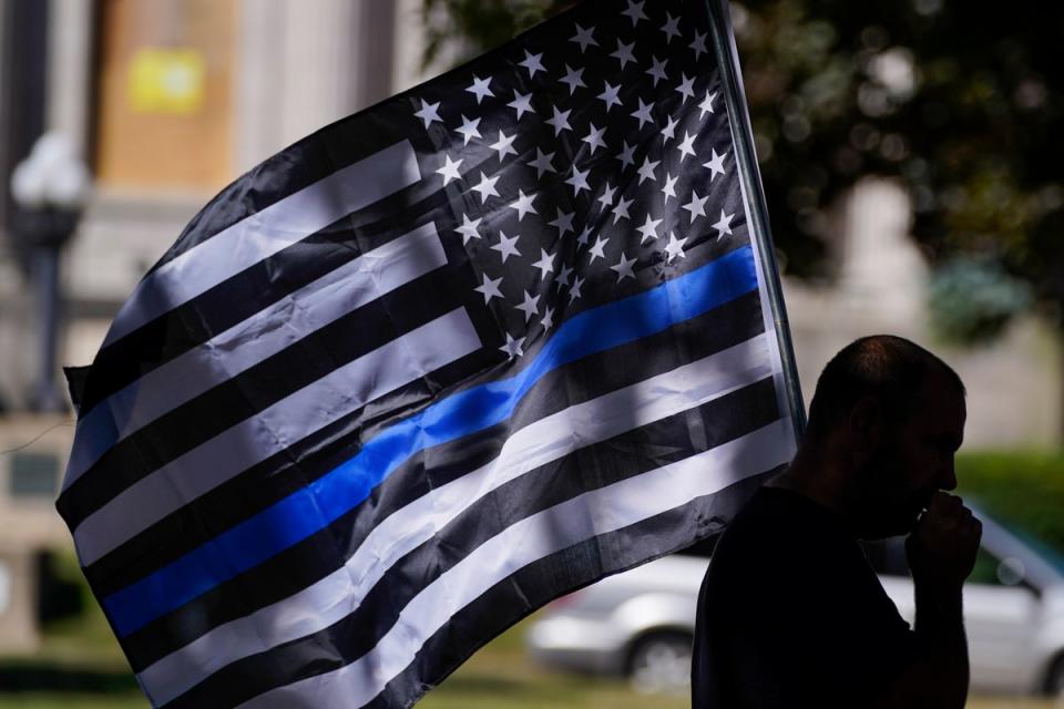 A man holds a thin blue line flag (Copyright 2020 The Associated Press. All rights reserved.)