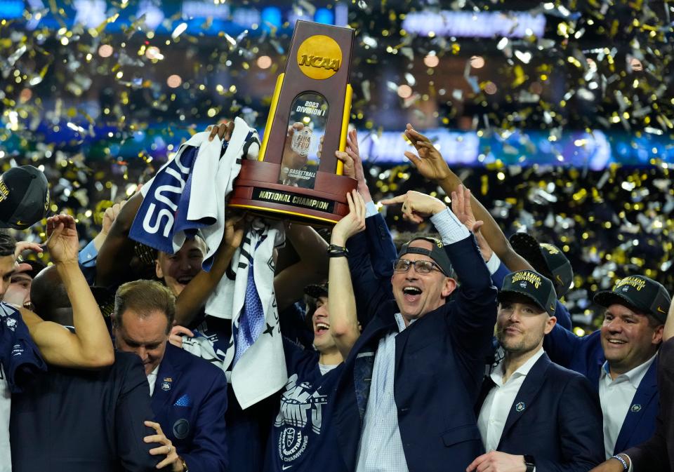 UConn coach Dan Hurley holds the 2023 national championship trophy aloft after a win over San Diego State. The Huskies are the No. 1 overall seed entering the 2024 tourney and are seeking to become the first repeat winner since the 2007 Florida Gators.