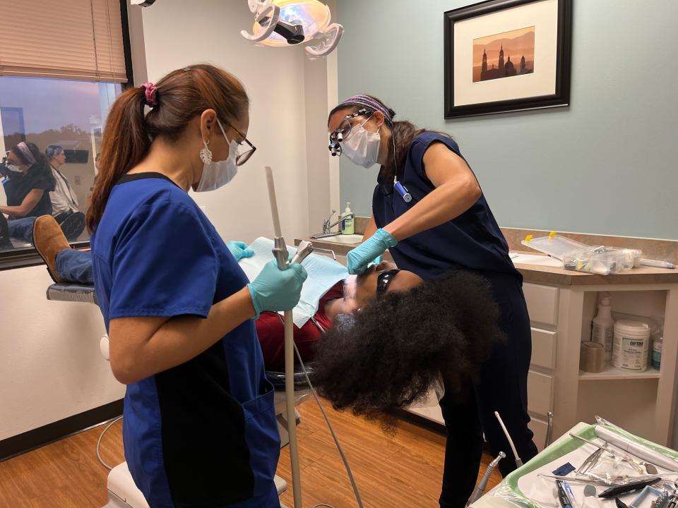 Dr. Aliisha Choucair and dental assistant Cristy Werner work on a filling for Chris Watkins on Saturday during the Capital Area Dental Foundation's Dental Day for Season for Caring.
