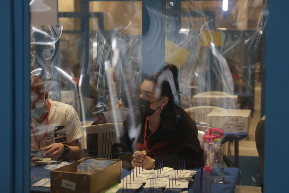 Workers count votes in Israel's national elections from behind plastic screens to help curb the spread of the coronavirus, at the Knesset in Jerusalem, Thursday, March 25, 2021. (AP Photo/Maya Alleruzzo)