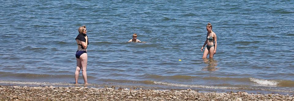 Swimmers wade into Wollaston Beach in Quincy.
