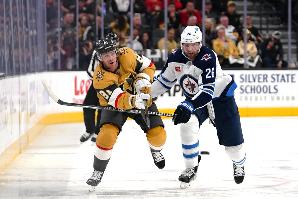 Vegas Golden Knights center Jonathan Marchessault (81) passes the puck up the ice past Winnipeg Jets right wing Blake Wheeler (26) during the second period of Game 2 of an NHL hockey Stanley Cup first-round playoff series Thursday, April 20, 2023, in Las Vegas. (AP Photo/Lucas Peltier)