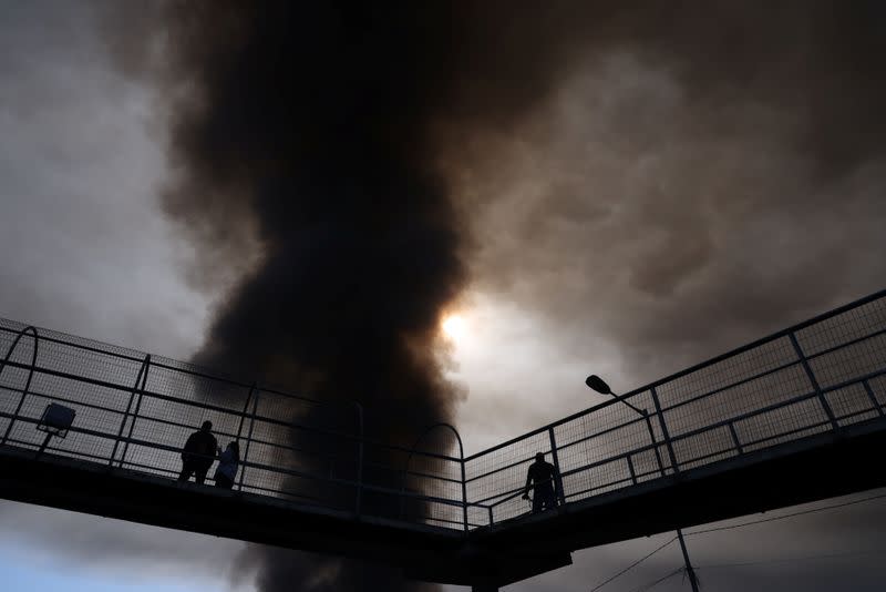 A smoke column rises from a fire in a factory in Santiago