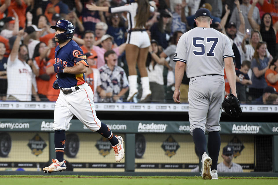 Houston Astros' Jose Altuve, left, rounds the bases after hitting a winning three-run home run as New York Yankees relief pitcher Chad Green (57) walks off the field during the ninth inning of a baseball game Sunday, July 11, 2021, in Houston. (AP Photo/Eric Christian Smith)