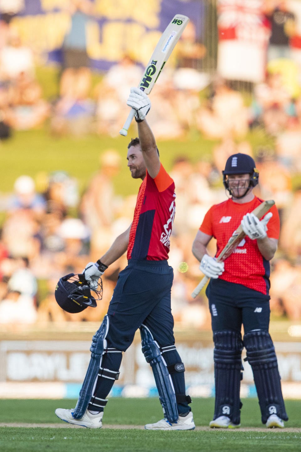 England's David Milan celebrates his century next to England captain Eion Morgan, right, during the T20 cricket match between England and New Zealand in Napier, New Zealand, Friday, Nov. 8, 2019. (John Cowpland/Photosport via AP)