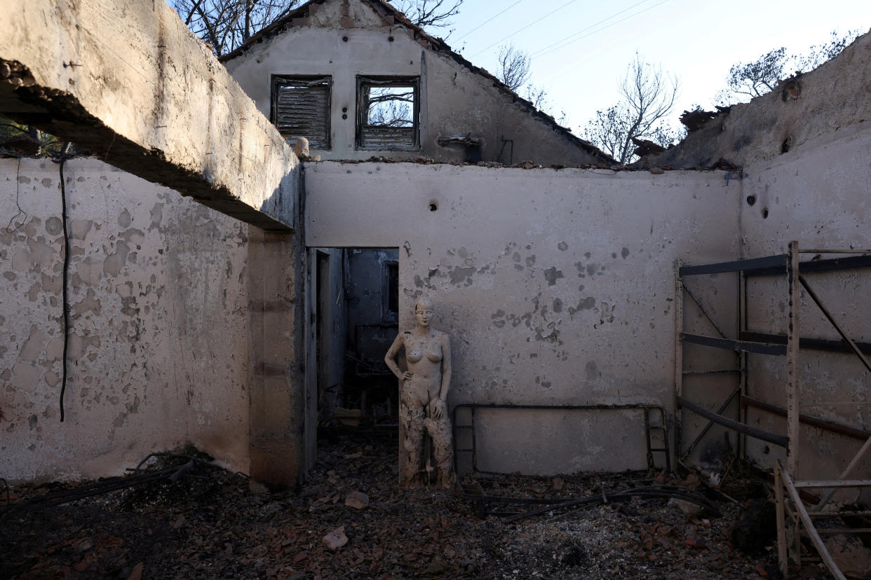 Houses burned by a wildfire in the Penteli area near Athens on Monday. 