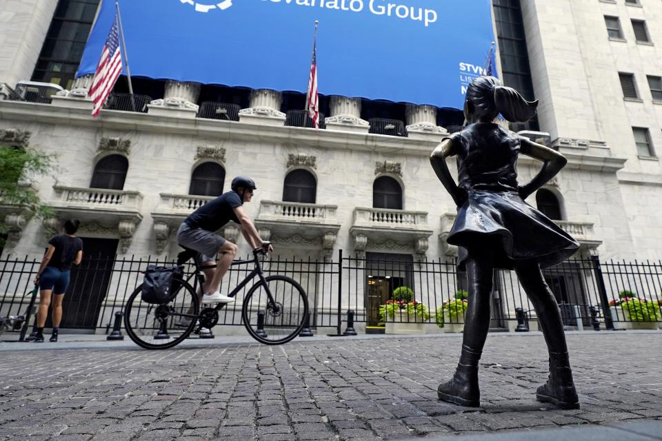 FILE - The Fearless Girl statue faces the New York Stock Exchange, Tuesday, July 20, 2021. Stocks are off to a mixed start on Wall Street, Friday, Aug. 13 as gains for communications and health care companies are checked by weakness in energy and other sectors.  (AP Photo/Richard Drew)