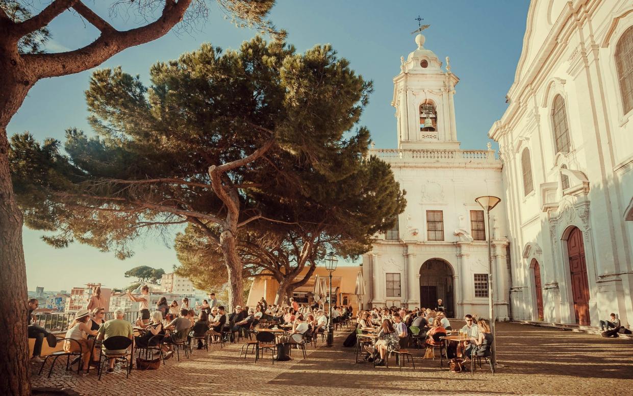 People dining outdoors in Lisbon's oldest district - Radiokukka/iStock Editorial