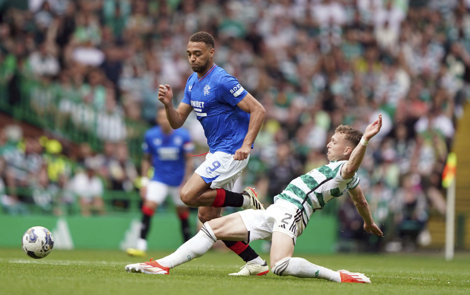 Rangers' Cyriel Dessers, background and Celtic's Alistair Johnston vie for the ball, during the Scottish Premiership soccer match between Glasgow Rangers and Celtic Glasgow, at the Celtic Park, in Glasgow, Scotland, Saturday May 11, 2024. (Andrew Milligan/PA via AP)