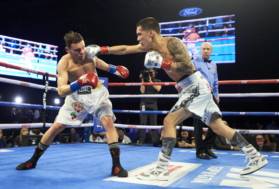 Oscar Valdez (R) hits Carmine Tommasone during the WBO featherweight title boxing match Saturday, Feb. 2, 2019, in Frisco, Texas. (AP Photo/Cooper Neill)