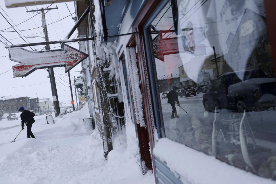 In this Feb. 22, 2019, photo, a man shovels snow outside the Polar Bar and Cafe on Front Street in Nome, Alaska. (AP Photo/Wong Maye-E)