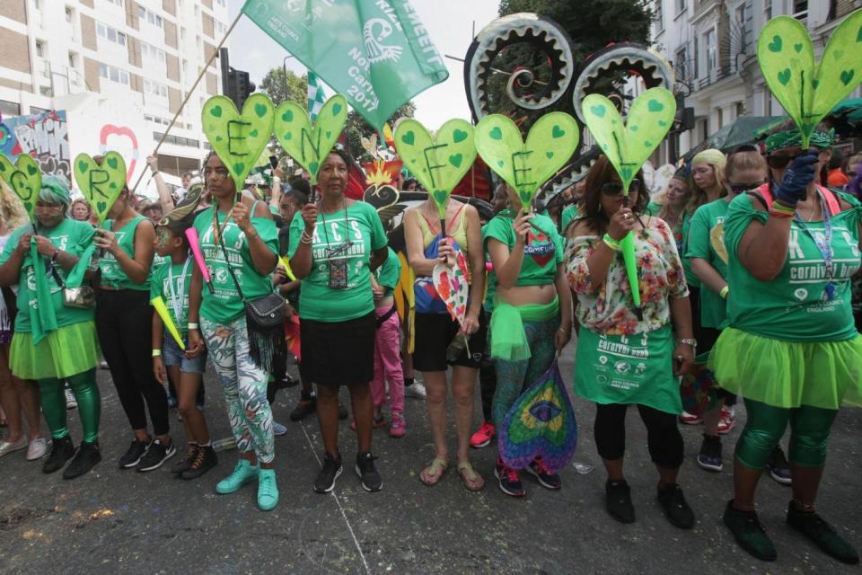 Carnival-goers observe a minute's silence. (PA)