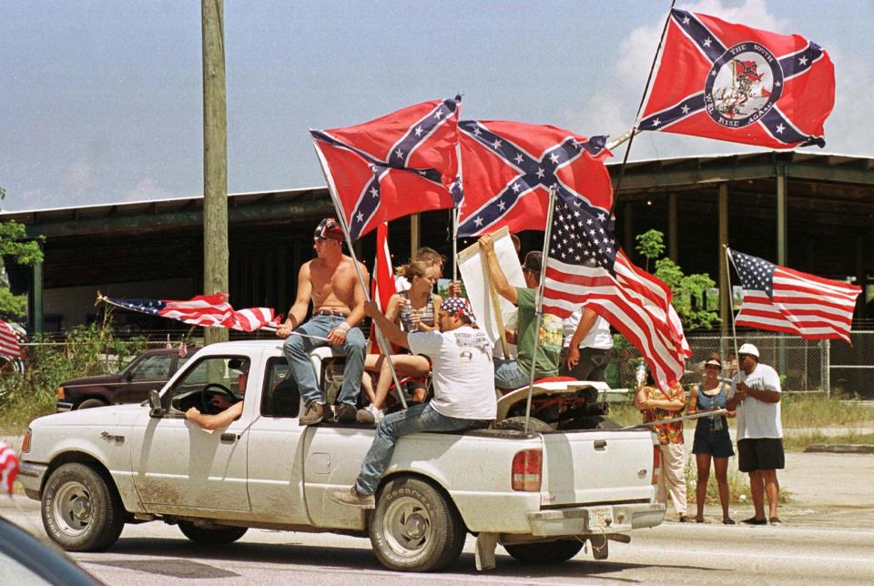 Banderas confederadas y de Estados Unidos portadas en Miami en 2000. (Reuters)