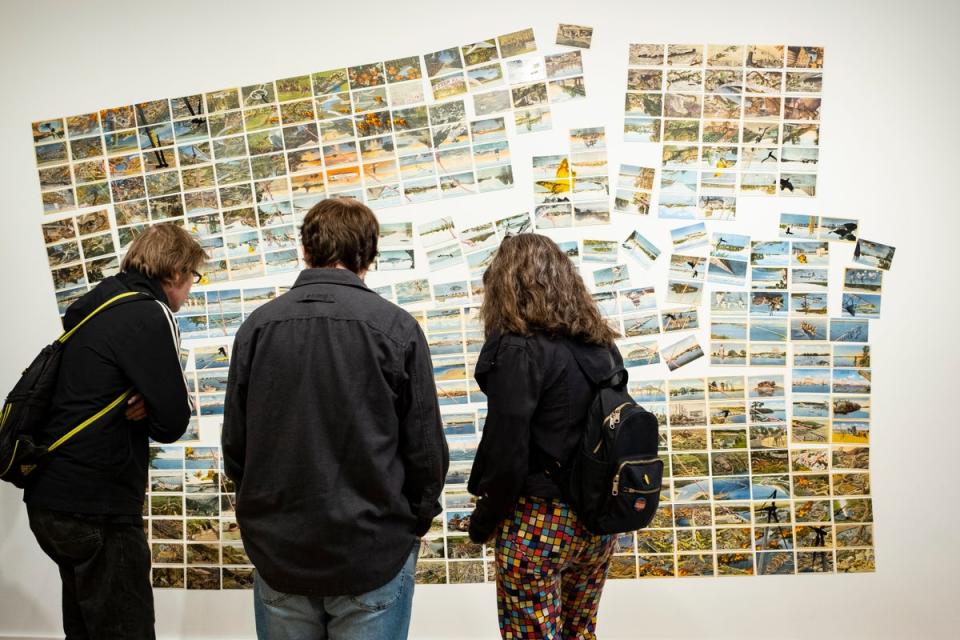 Visitors to The Climate Museum view the postcard mural, Someday, all this, by the artist David Opdyke (Climate Museum/Sari Goodfriend)