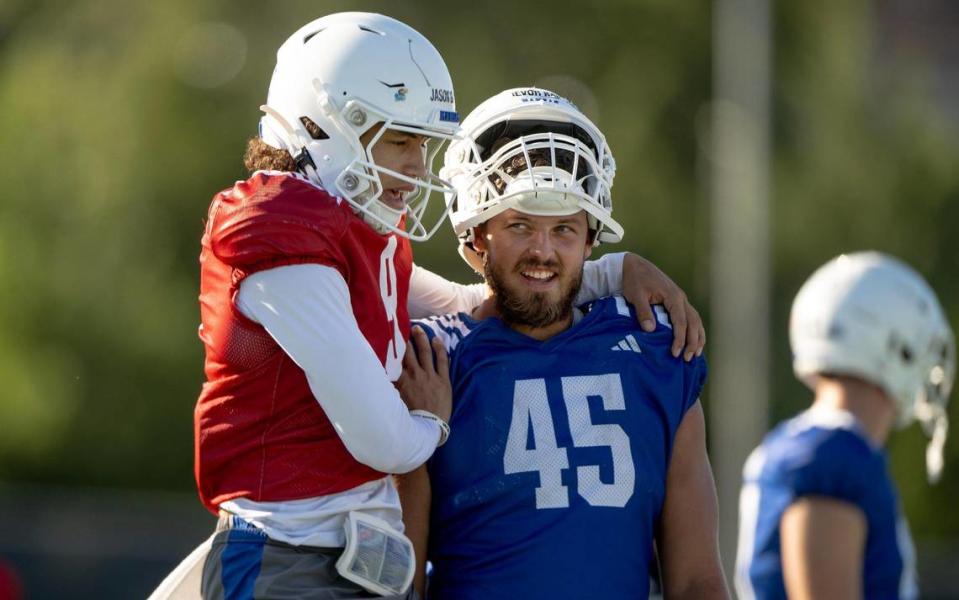 Kansas quarterback Jason Bean (9) jumps on tight end Trevor Kardell (45) during a KU football practice on Wednesday, Aug. 16, 2023, in Lawrence, Kan.