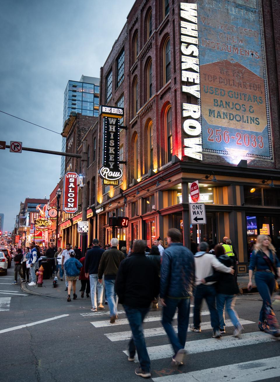 People walk in front of Whiskey Row in downtown Nashville on March 31.