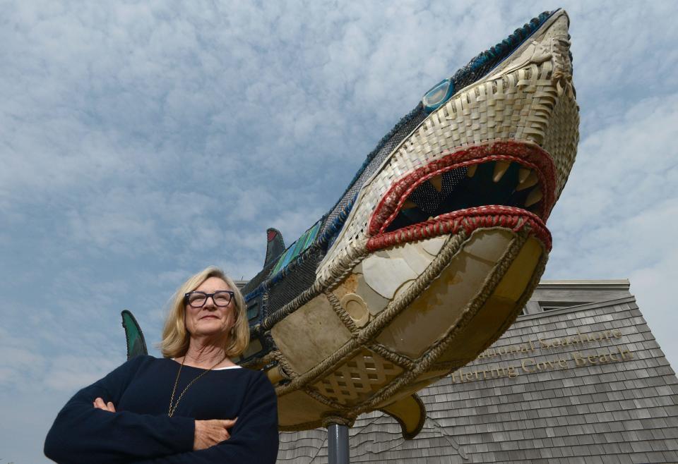 Artist Cindy Pease Roe beside her shark called "Mama Shug" made entirely of found plastic trash that was unveiled at Herring Cove Beach in Provincetown on Thursday, World Ocean Day.