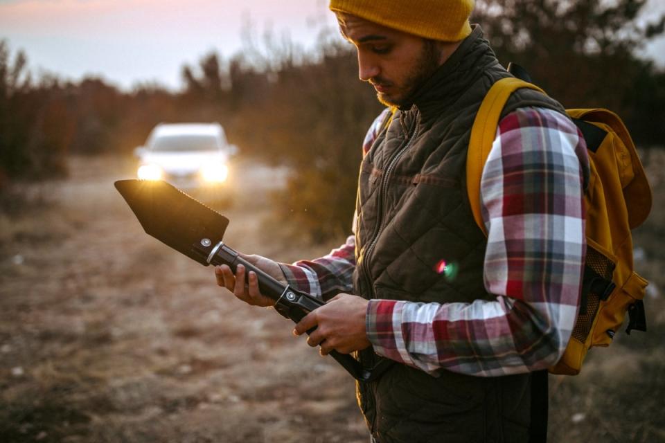 Man holding camp shovel