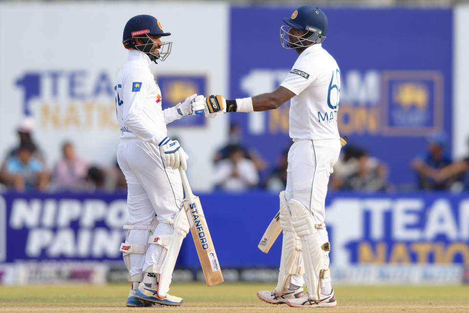 Sri Lanka's captain Dhananjaya de Silva, left, and teammate Angelo Mathews touch gloves as they bat on the third day of the first cricket test match between New Zealand and Sri Lanka in Galle, Sri Lanka, Friday, Sept. 20, 2024. (AP Photo/Viraj Kothalawala)