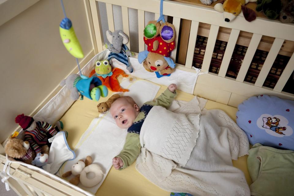 Mandatory Credit: Photo by imageBROKER/Shutterstock (1377779a) MODEL RELEASED Baby boy, 2 months, lying in his crib, surrounded by numerous stuffed animals, and observing a hanging mobile, Germany, Europe VARIOUS