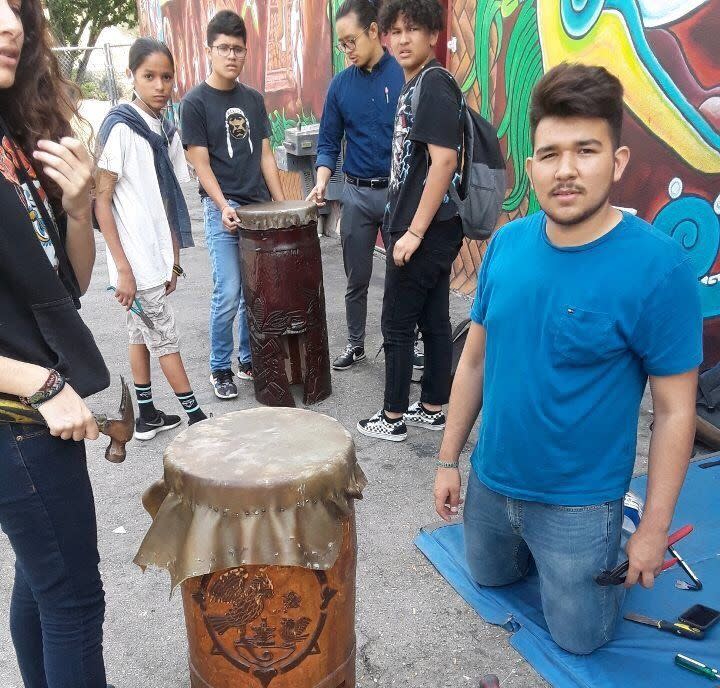 Antonio Tlaloc Carrillo, right, re-skinning a drum with other students at Semillas Community Schools in 2017. (Photo: Marcos Aguilar)