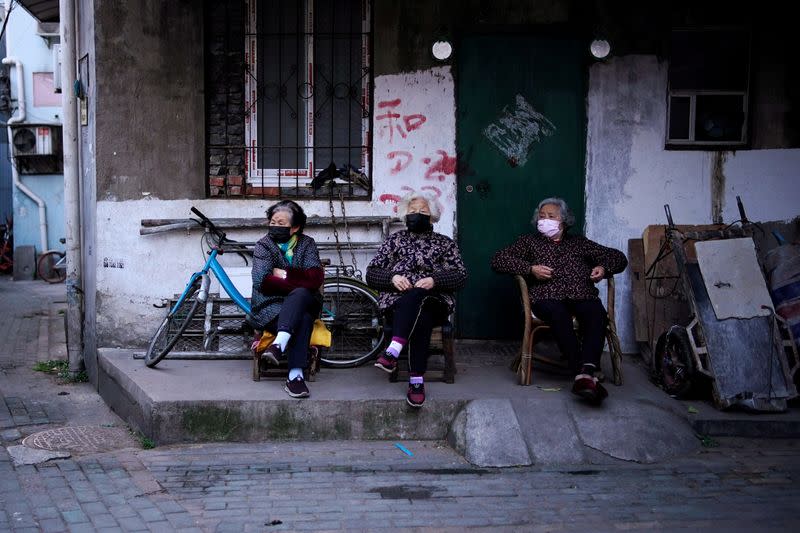 Residents wearing face masks are seen at a blocked residential area after the lockdown was lifted in Wuhan