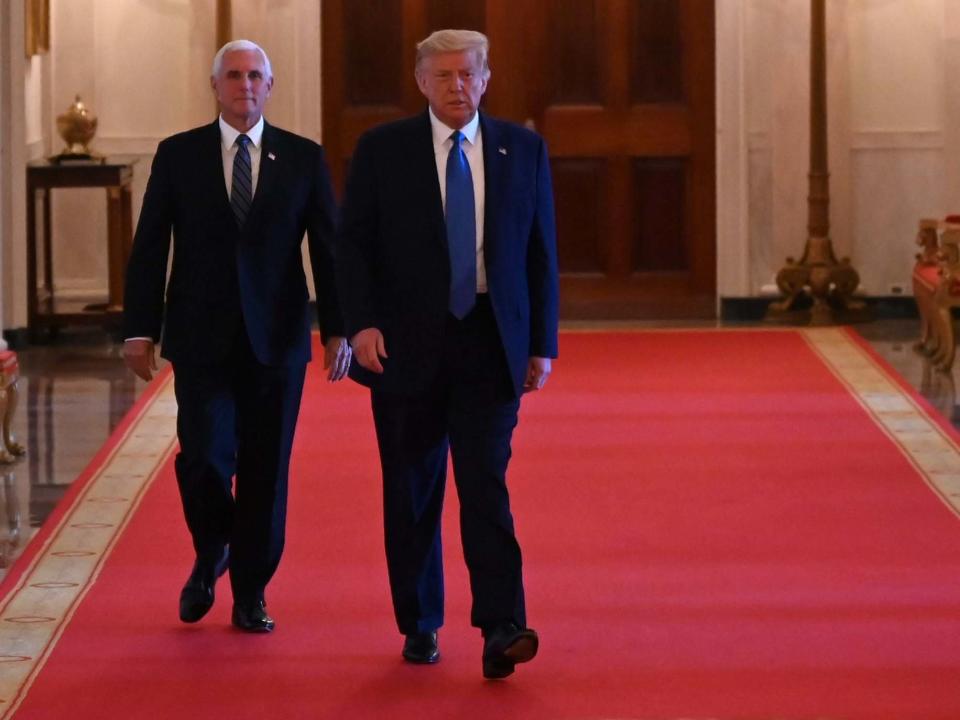 President Donald Trump and Vice-President Mike Pence arrive to participate in a roundtable with stakeholders positively impacted by law enforcement, in the East Room of the White House: AFP via Getty Images