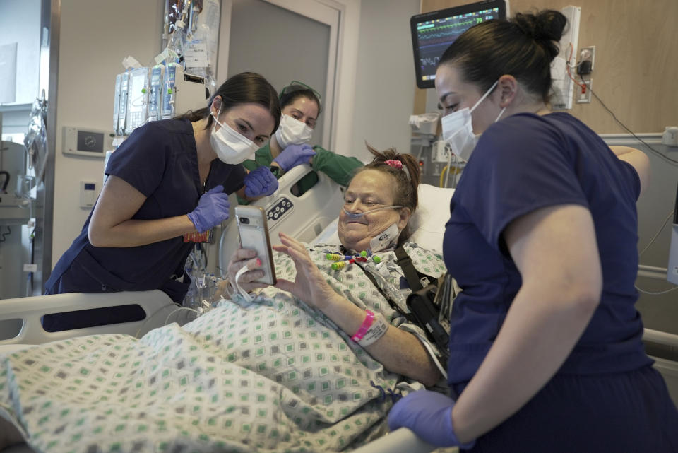 Lisa Pisano looks at photos of her dog after her surgeries at NYU Langone Health in New York on Monday, April 22, 2024. Doctors transplanted a pig kidney into Pisano, who was near death, part of a dramatic pair of surgeries that also included a fix for her failing heart. (AP Photo/Shelby Lum)