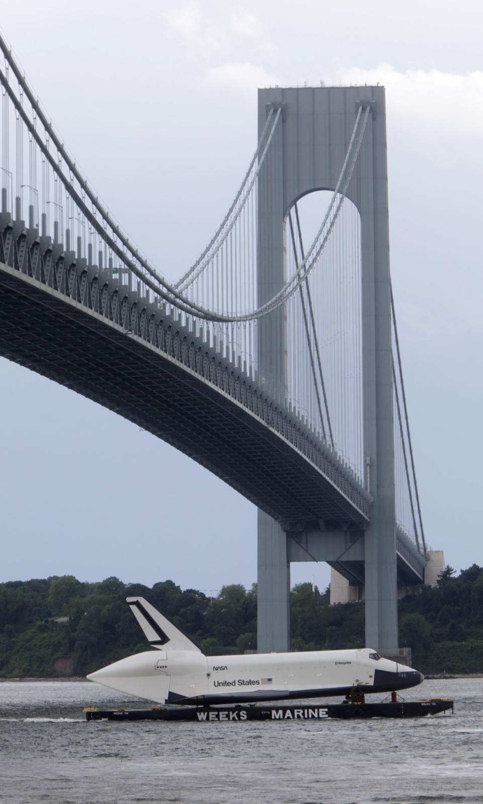 The space shuttle Enterprise is towed on a barge underneath the Verrazano-Narrows Bridge in New York, Sunday, June 3, 2012. The prototype space shuttle that arrived in New York City by air earlier this spring is on the move again, this time by sea, to it's final resting place at the Intrepid Sea, Air and Space Museum on the west side of Manhattan. (AP Photo/Seth Wenig)