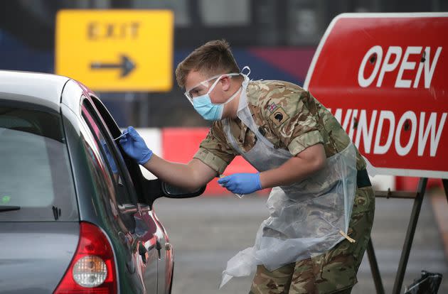 A soldier from 2 Scots Royal Regiment of Scotland take a test sample at a Covid-19 testing centre at Glasgow airport.