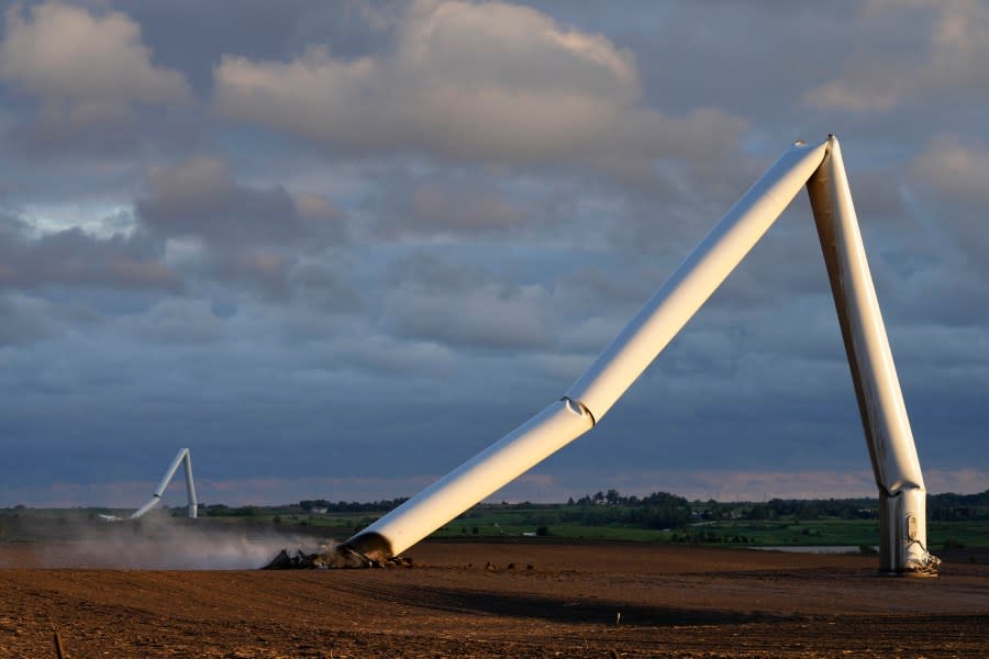 The remains of a tornado-damaged wind turbine touch the ground in a field, Tuesday, May 21, 2024, near Prescott, Iowa. (AP Photo/Charlie Neibergall)