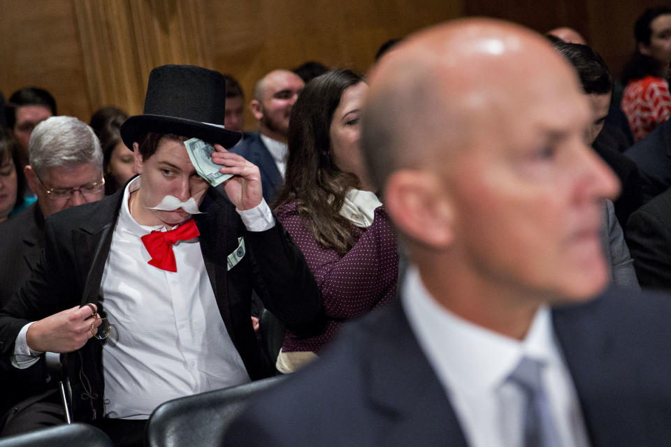 A demonstrator sits in costume behind Richard Smith, former chairman and chief executive officer of Equifax Inc., right, before a Senate Banking Committee hearing in Washington, D.C., on Wednesday, Oct. 4, 2017. (Photo: Bloomberg via Getty Images)