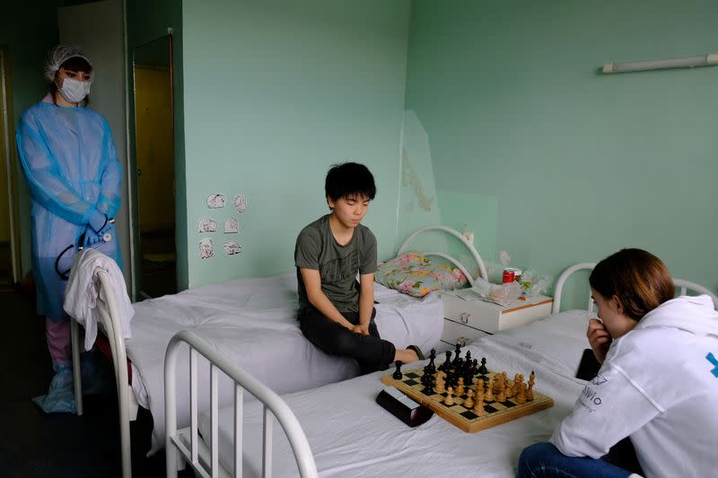 Chess players from France look at the board during a game at a hospital in Murmansk