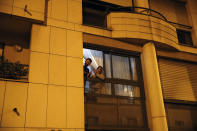 Parisians, in spirit at least, applaud the caregivers and police for their work, as the coronavirus ravaged communities across the country, in Paris, Wednesday, March 18, 2020. In France at 8pm sharp local time French citizens leaned out of windows and dangled from balconies and began applauding and whistling in unison to thank those on the front lines of the pandemic that has already claimed scores of lives. The move was an organized initiative that began circulating on social media. France has been on effective lockdown since midday on Tuesday as French President Emmanuel Macron tightened restrictions on movement to fight the spread of the virus. (AP Photo/Francois Mori)